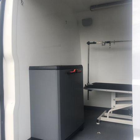 mobile dog grooming van with storage cabinet and grooming table setup