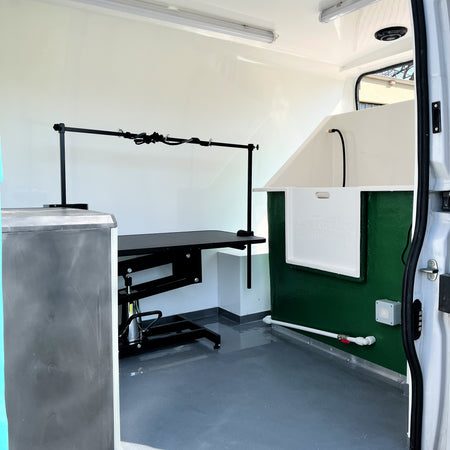 mobile dog grooming van interior with grooming table and bath setup