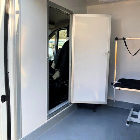 mobile dog grooming van interior with cabin access door and grooming table