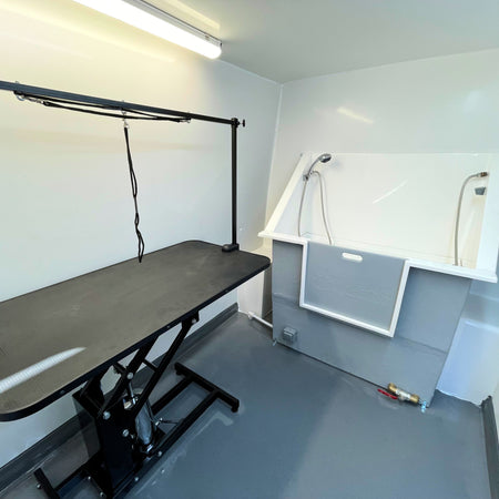 mobile dog grooming van interior with grooming table and bath station